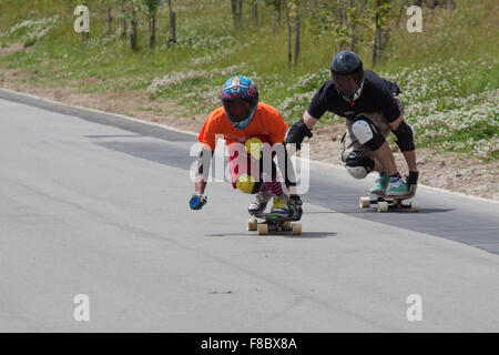 Due down hill skateboarders in nero pieno viso visiere guardare piuttosto misterioso Foto Stock