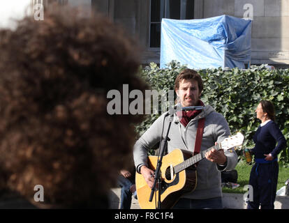 Un arrabbiato cercando busker riproduce in Trafalgar Square Foto Stock