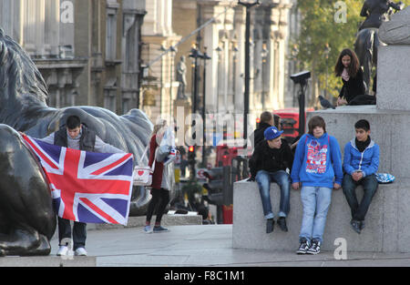 Un giovane uomo può contenere fino a union jack in Trafalgar Square Foto Stock