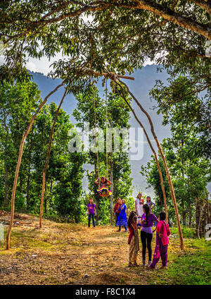 Nepalesi per bambini che giocano su una tradizionale swing di bambù chiamato linge ping Foto Stock