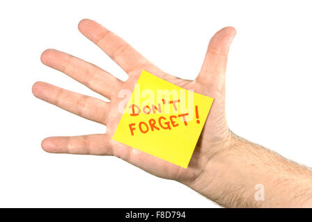 Mano tesa con un giallo post-it-nota bloccato al palm. Nota legge non dimenticare! In lettere rosse. Foto Stock