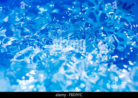 Il simbolo del fiocco di neve si scioglie in acqua scende sfondo astratto Foto Stock