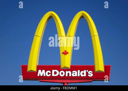 Il cartello canadese Golden Arches della catena di ristoranti McDonalds Hamburger Contro un cielo blu sfondo Foto Stock