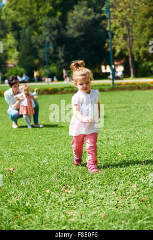 Felice la madre e il bambino bambino in posizione di parcheggio facendo i primi passi . Camminare e avvolgente. Foto Stock