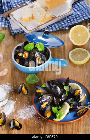 Piastre di cozze cotte al vapore su un sfondo di legno. Vista da sopra Foto Stock