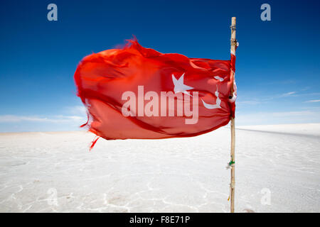 Bandiera turca sventolare nel Salar di Uyuni contro un cielo blu. Bolivia Foto Stock