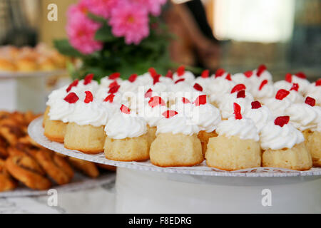 Il rum baba (o baba au rhum) una piccola torta lievito saturo in rum e farcito con panna montata o crema pasticcera Foto Stock