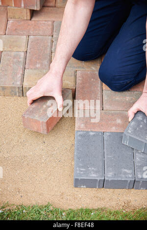 L'uomo la posa di blocchi per il Patio Foto Stock