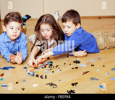 Divertente carino i bambini giocando lego a casa, ragazzi e una ragazza sorridente, prima educazione Foto Stock