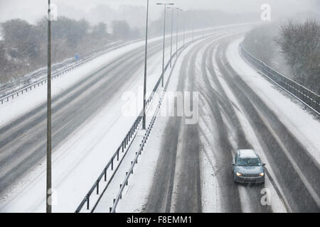 Unica vettura in autostrada durante la tempesta di neve Foto Stock