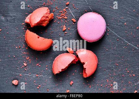 Alcuni appetitosi macarons di sapori diversi su una superficie di ardesia Foto Stock