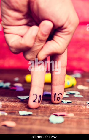Primo piano della mano di un giovane uomo che fa l'azione di camminare con le sue dita con il numero 2016, come il nuovo anno, scritto Foto Stock