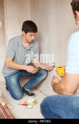 Elettricista con apprendista Lavorare nella nuova casa Foto Stock