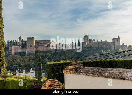 Palazzo Alhambra di Granada in Spagna con in primo piano la parete e copertura di case che si affaccia sul magnifico monumento Foto Stock