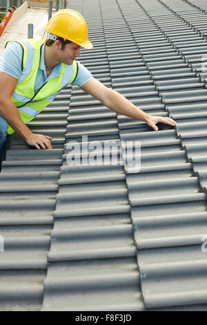Builder lavorando sul tetto del nuovo edificio Foto Stock