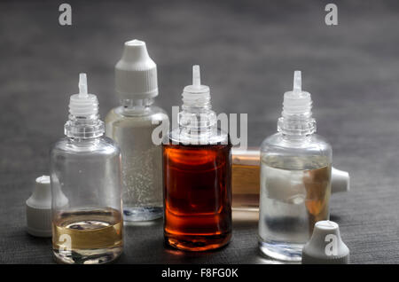 E sigarette flacone di liquido sul tavolo di legno, close up Foto Stock