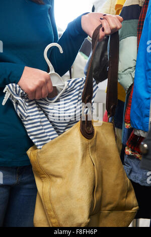 Donna di rubare i vestiti da memorizzare Foto Stock
