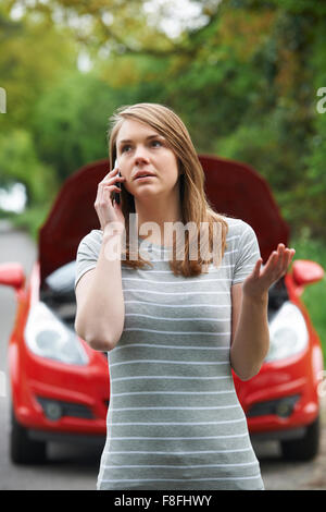 Automobilista femmina telefonare per aiutare dopo la Ripartizione Foto Stock