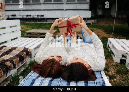 Le ragazze si trovano e spacchetta un regalo Foto Stock