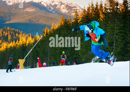 Snowboarder jumping in Bukovel ski resort. Bukovel è la più rinomata stazione sciistica in Ucraina. Foto Stock