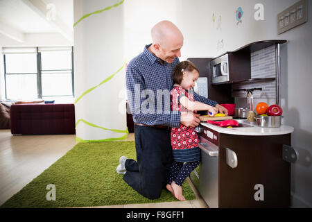 Padre e figlia giocando in cucina giocattolo Foto Stock