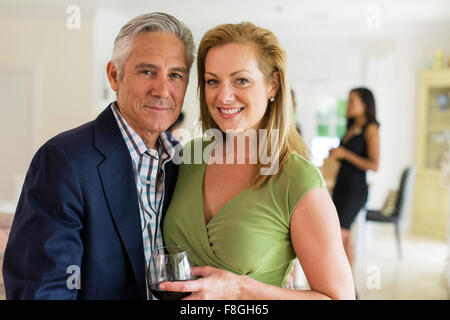 Coppia caucasica bevendo vino in festa Foto Stock