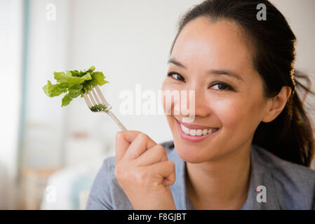 Donna cinese di mangiare insalata Foto Stock