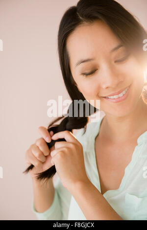 Donna cinese trecciatura i suoi capelli Foto Stock