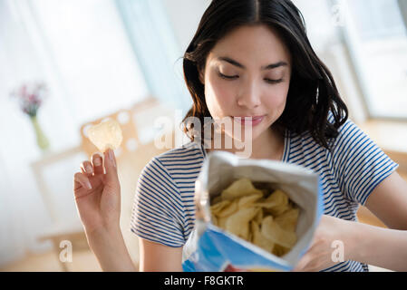 Donna ispanica ingredienti di lettura sul sacchetto di patatine Foto Stock