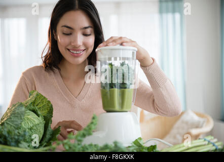 Donna ispanica blending frullato sano Foto Stock