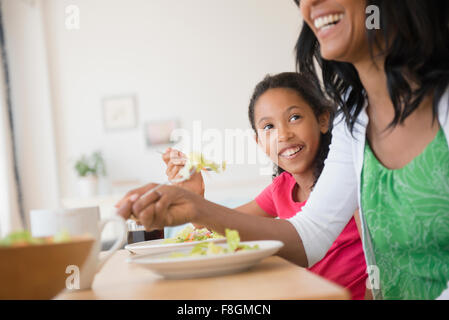 Madre e figlia mangiare insalata Foto Stock