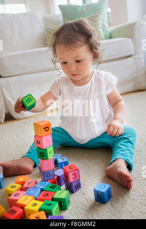 Razza mista bambina gioca con blocchi Foto Stock