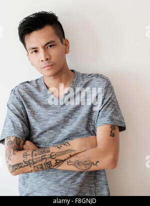 Grave uomo asiatico con le braccia incrociate Foto Stock