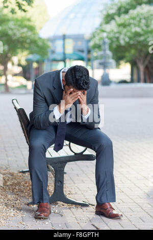 Frustrato commerciante indiano seduta sul banco di lavoro Foto Stock