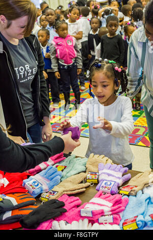 Detroit, Michigan STATI UNITI D'AMERICA. Il 9 dicembre 2015. Bambini a Dossin scuola elementare ricevono i guanti da una carità denominati muffole per Detroit. La carità è la distribuzione di muffole per 26.000 Detroit pubbliche scuole elementari di studenti; la maggior parte sono stati donati da dipendenti di Chrysler Fiat Automobiles. Credito: Jim West/Alamy Live News Foto Stock