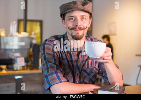 Uomo caucasico di bere il caffè nella caffetteria Foto Stock