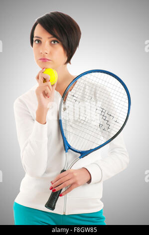 Ragazza giovane con la racchetta da tennis e bal isolato su bianco Foto Stock