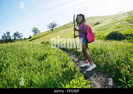 Nero ragazza camminare sul percorso rurale Foto Stock