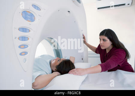 Infermiera ispanica esame paziente nella macchina MRI Foto Stock