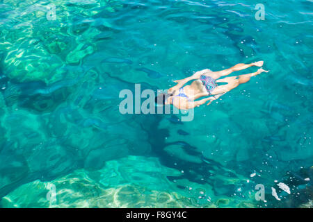 Donna ispanica nuotare nell'oceano Foto Stock