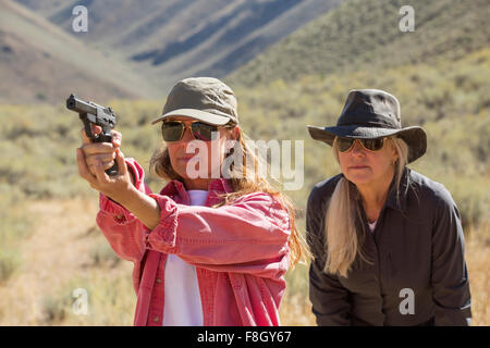 Donne caucasici pistola di puntamento all'aperto Foto Stock