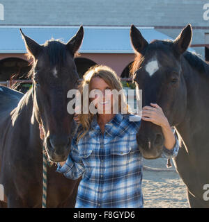 Il rancher caucasica sorridente con i cavalli Foto Stock