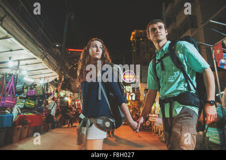 Turisti caucasica tenendo le mani nel mercato a notte Foto Stock