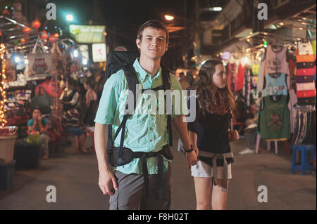 Turisti caucasica tenendo le mani nel mercato a notte Foto Stock