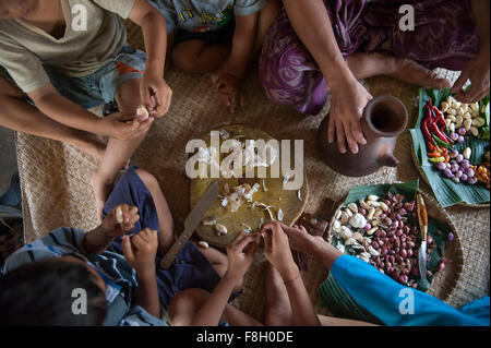 Famiglia asiatica mangiare sulla stuoia tessuta Foto Stock