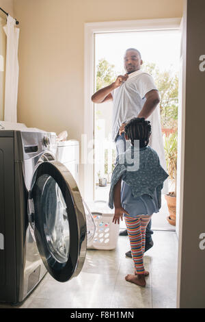 African American padre e figlia facendo servizio lavanderia Foto Stock