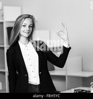 Giovane bella donna d'affari fa segno OK Foto Stock