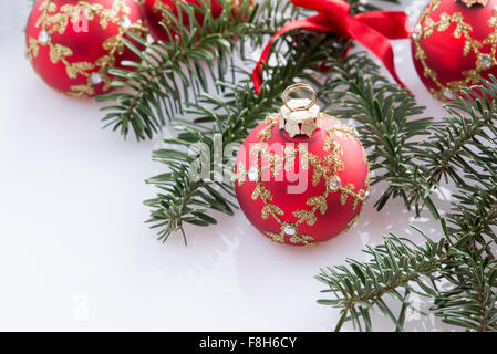 Red palla di Natale decorazioni e abete su sfondo bianco Foto Stock