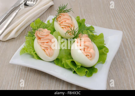 Uova ripiene di pâté di salmone in foglie di lattuga Foto Stock