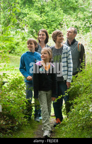 Una famiglia di cinque passeggiate attraverso la foresta a Crathes Castle in Aberdeenshire, Scozia. Foto Stock